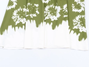Close-up of green and white tie-dye floral pattern on soft lightweight dress hem