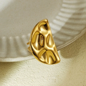 Detailed close-up of golden stainless steel ring with hammered texture and hollow dome design