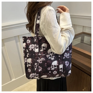 Detailed view of large tote bag with gothic skull and floral pattern on female model
