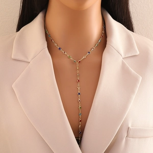 Elegant gold Y-shaped necklace with colorful round gemstones worn by a model