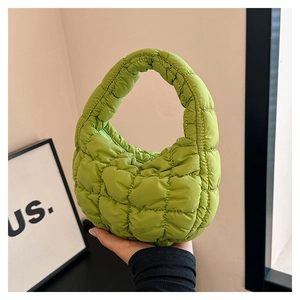 Close-up of green quilted bubble cloud handbag with soft padded texture and top handle