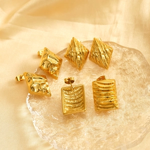 Golden square and rhombus textured stainless steel earrings on champagne silk background