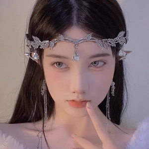 Close-up of silver crystal crown leaf bridal headpiece and elven ear jewelry