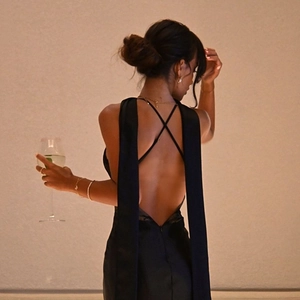Detail of elegant black backless evening dress with slim crisscross straps and long ties