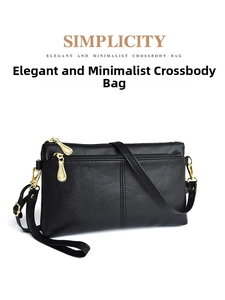 Close-up of black litchi grain leather crossbody bag with golden hardware zippers
