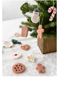 Detailed close-up of wool felt Christmas ornaments with hand-stitched white sewing details