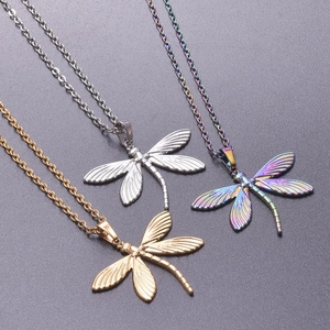 Macro detail of dragonfly pendants in silver, gold and rainbow finishes with textured wings