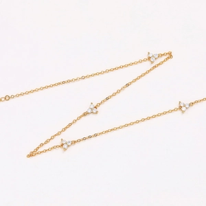 Detailed macro view of delicate gold choker necklace with four zircon flower clusters