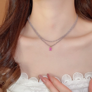 Close-up of a double-layer beaded necklace with pink rectangular crystal pendant on model