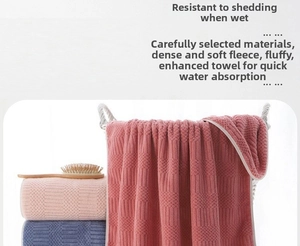Close-up of thick coral fleece bath towels with honeycomb texture in pink and navy blue