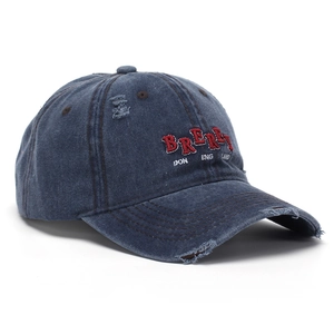 Detail of navy blue washed denim baseball cap with 3D embroidery and distressed texture