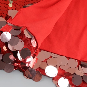 Detailed close-up of red sequin stitching on feather patchwork evening party dress