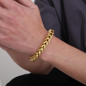 Detail of masculine gold-plated stainless steel franco link bracelet on model's wrist