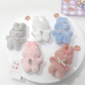 Cinq breloques de lapins en peluche colorés avec ouverture au dos sur plateau blanc