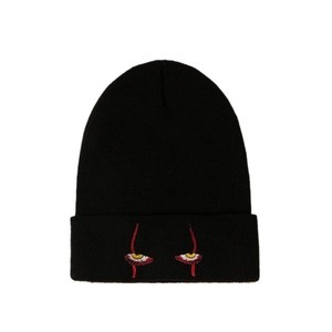 Black knitted beanie hat featuring unique yellow eye embroidery on pure white background