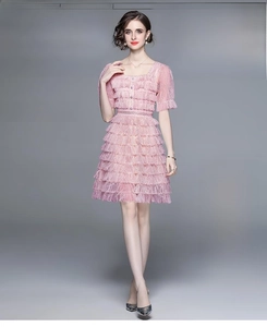 Détail de la robe en dentelle rose avec encolure carrée et jupe à volants multicouches