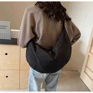 Model back view of black nylon crescent crossbody bag showing large capacity and fit