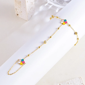 Détail macro du bracelet bague doré avec fleurs en émail coloré et zircons brillants