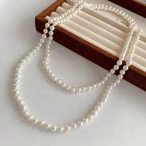 Elegant French vintage double-layer pearl necklace displayed on brown velvet tray