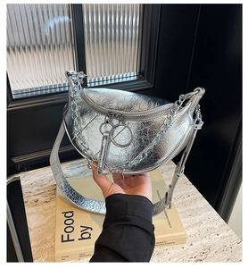 Detail of silver metallic crescent bag with pleated texture and round ring zipper