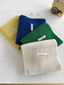 Dettaglio di quattro sciarpe in maglia spessa in giallo, blu, verde e bianco