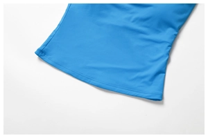 Zoom sur l'ourlet du gilet de sport bleu montrant les coutures doubles et le tissu élastique