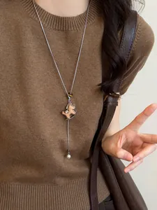 Detail of wooden rocking horse pendant with tiger eye bead and pearl on a long chain