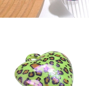 Detailed macro of a green leopard print heart pendant with a shiny resin finish
