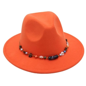 Detail of bright orange wool fedora featuring a beaded decorative band in bohemian style