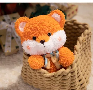 Close-up of fluffy orange plush fox toy with checkered bow in a woven gift basket