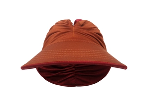 Detail of caramel sun hat featuring pleated texture and burgundy interior contrast