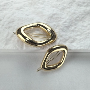 Minimalist irregular geometric oval gold metal hair clips for women in a professional shot