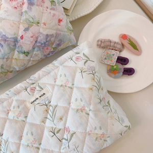 Detail of floral quilted cotton makeup bags with elegant stitching and soft fabric texture