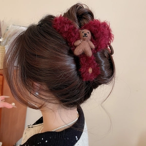 Rear view of red plush bow claw clip with cute brown bear on hair bun style