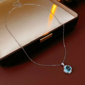 Detail of blue zircon rose flower pendant on silk lining with professional lighting