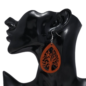 Détail de boucle d'oreille en bois avec arbre de vie sur un mannequin noir