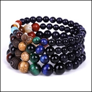 Detailed stack of four solar system themed beaded bracelets with colorful planet textures