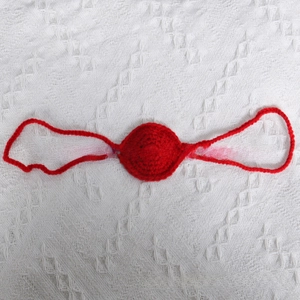 Detail of red handmade crochet nose accessory for Halloween party and photo props