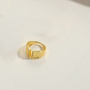 Detail of wide gold adjustable ring with unique texture and small inlaid gemstone