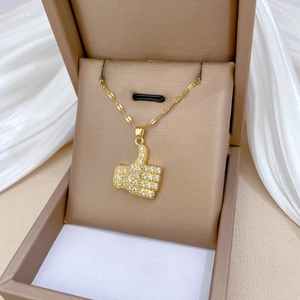 Elegant gold titanium steel necklace featuring a sparkling pavé crystal thumb up pendant