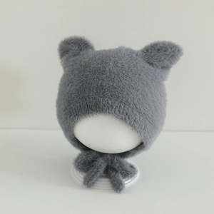 Detail of grey faux mink plush baby hat featuring cute round bear ears and long chin ties