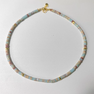 Detail of beaded natural stone necklace with cylindrical beads and gold heart clasp