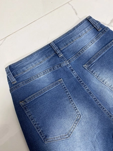 Dettaglio dei jeans in denim blu scuro con vita posteriore e cuciture dorate