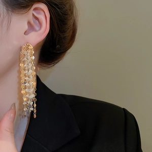 Detail of 18k gold plated fringe earrings featuring elegant clear crystal tassels on a model