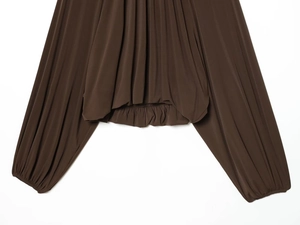 Detail of dark brown blouse featuring pleated fabric texture and elastic lantern sleeves
