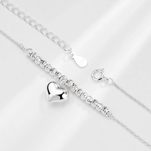Polished S925 sterling silver heart necklace with laser-cut beads on white background