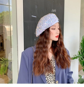 Close-up of a stylish beret hat featuring shimmering iridescent sequins in a modern design