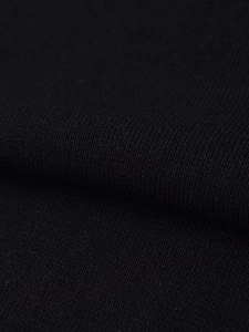 Détail macro du tissu en maille noire montrant la texture uniforme et les coutures fines