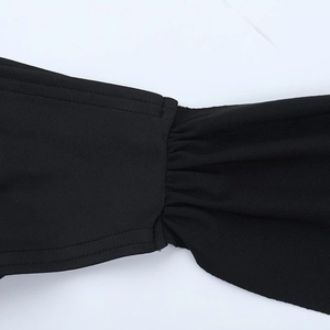 Detail of black dress fabric showing intricate stitching and mesh pleating textures