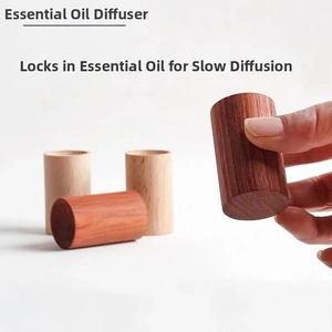 Gros plan sur un diffuseur d'huiles essentielles en bois tenu par la main délicate
